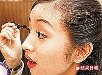 抵達拍攝現場後，林依晨精神奕奕地刷眼睫毛。  2003.07.10蘋果日報