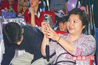 媽媽參加畢業典禮，在台下替女兒拍照留念。