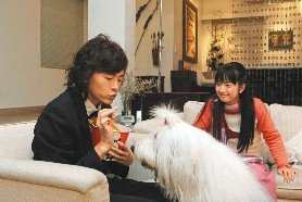 鄭元暢（左）、林依晨（右）在「惡作劇之吻」與古代牧羊犬「小可愛」搶著吃雞塊，玩得不亦樂乎。